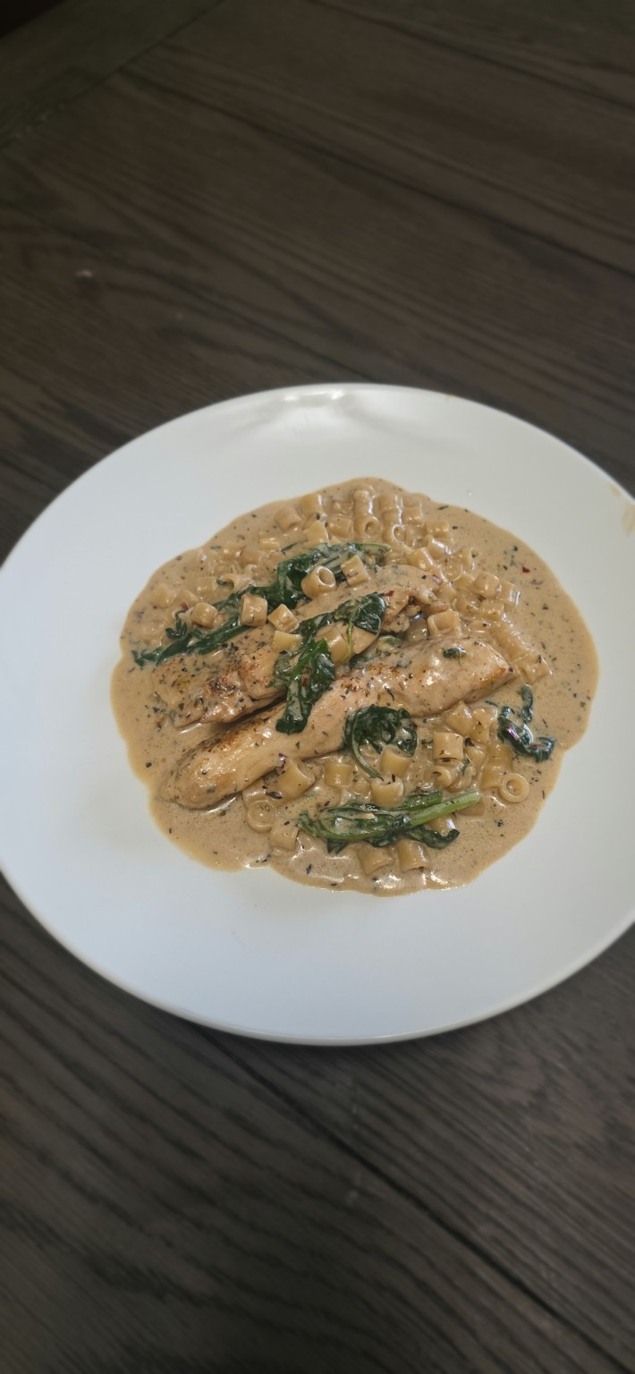 Creamy Parmesan chicken and ditalini plated with spinach